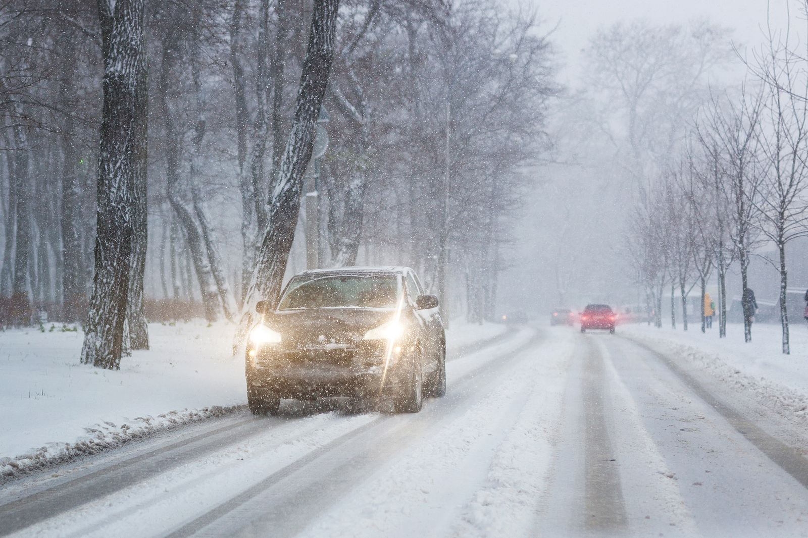 Cars Moving On Slippery Snowy Road At City Street During Heavy S